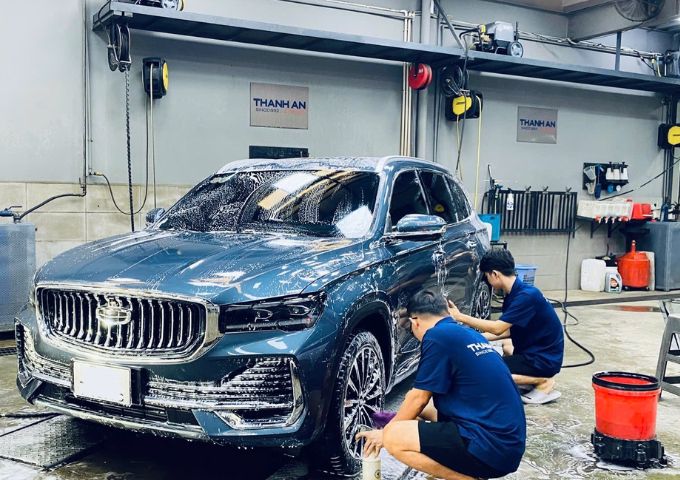 Nhân viên kỹ thuật đang rửa xe ô tô bằng máy xịt áp lực cao